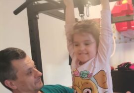 Devojčica radi zgibove, uz tatinu pomoć