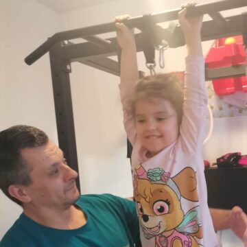 Devojčica radi zgibove, uz tatinu pomoć