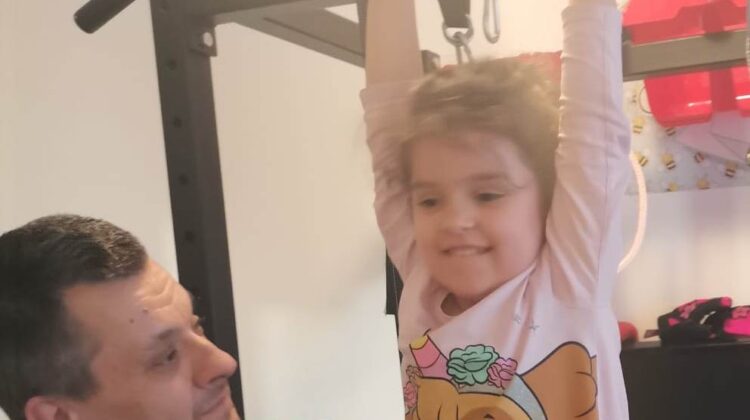 Devojčica radi zgibove, uz tatinu pomoć