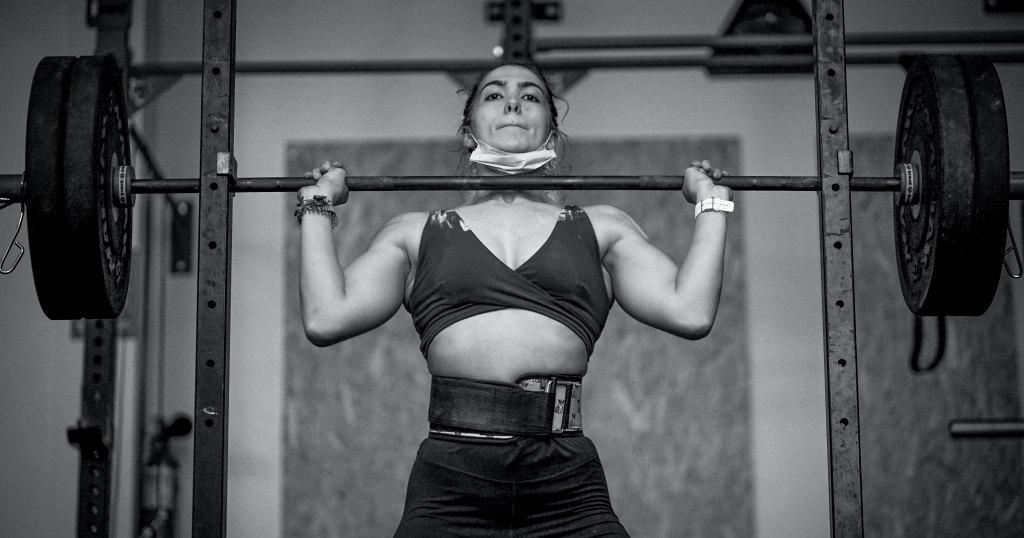 Podizanje tereta iznad glave. vidljiv je pojas za dizanje tegova.